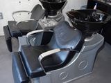 une chaise noire et argentée dans une pièce équipée d'un lavabo et d'un miroir