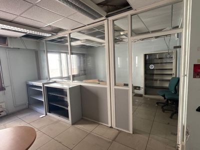 une pièce contenant un bureau, des étagères et une chaise