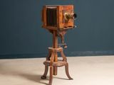 un vieil appareil photo en bois posé sur un tabouret en bois