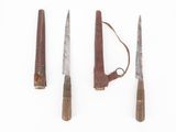 four knives are lined up in a row on a white surface