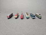 several toy trains are lined up in a row on a gray surface