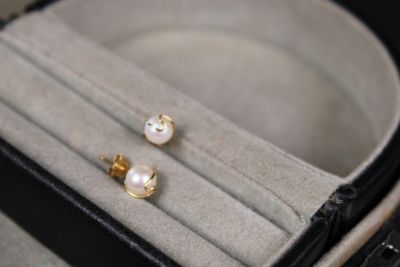 une paire de boucles d'oreilles en perles dans un écrin posé sur une table