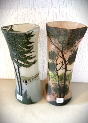 deux vases posés sur une table, sur lesquels sont peints des arbres