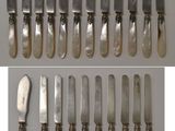 a set of six silverplated knives and a knife on a table