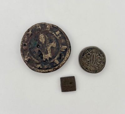 un gros plan d'une pièce de monnaie et d'une petite pièce posées sur une surface blanche