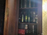 a tall wooden cabinet with a lot of bottles on it