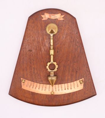 une horloge en bois sur laquelle sont représentés une clé en laiton et une règle