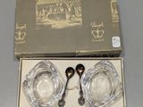deux cuillères en argent et un saladier en verre dans une boîte