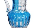 the blue glass pitcher is sitting on a clear base