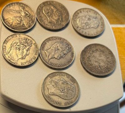 a lot of coins sitting on top of a white tray