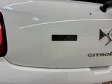 a close up of a white car with an x logo on it