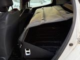 a white car with the door open in a parking lot