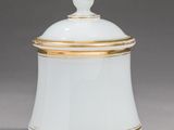 a white and gold covered jar with a gold rim