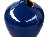 a blue vase with a gold rim on a white background