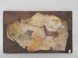 un morceau de pierre posé sur une planche en bois posée sur une table