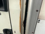 un gros plan sur la poignée d'une porte de camion blanc