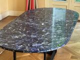 a marble table with a black base in a room