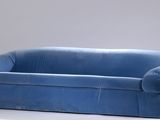 a blue couch that is sitting on a white table