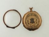 a gold pocket watch with a picture of a woman on it