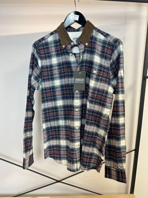 une chemise suspendue à un portant dans un magasin de vêtements