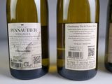 three bottles of white wine are lined up on a table