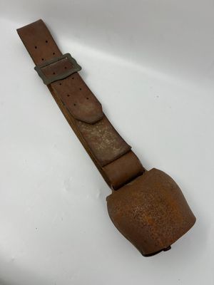 un gros plan d'un bracelet de montre en cuir marron posé sur une surface blanche