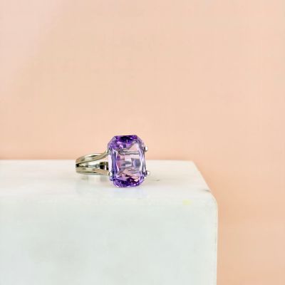 an amethorate ring with a purple stone on top of a white block
