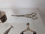 a glass table topped with a silver object and a pair of scissors