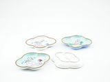 quatre assiettes en porcelaine ornées de fleurs et de feuilles sur un fond blanc