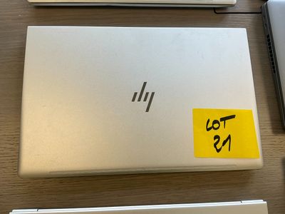 three laptops are sitting on a table with stickers on them