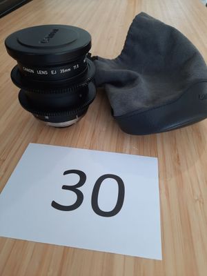 un appareil photo et un objectif posés sur une table sur laquelle est inscrit le chiffre 30
