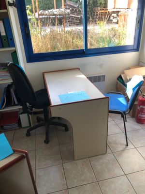 a desk and chair in a room with a large window
