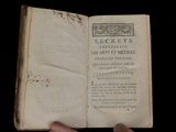 someone is holding an open book in their hand on a black background