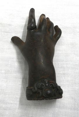 a statue of a hand holding something in it ' s right hand
