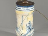 a blue and white vase with a light on top of it