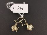 a pair of gold earrings with a small bird on them