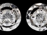 paire de boucles d'oreilles en diamant sur fond noir, avec reflet