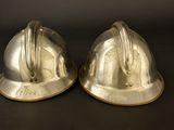 two helmets that are sitting on a black surface