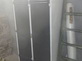 une armoire haute dans une pièce, avec une échelle à côté