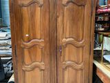 une armoire en bois dans une pièce où se trouvent de nombreux meubles