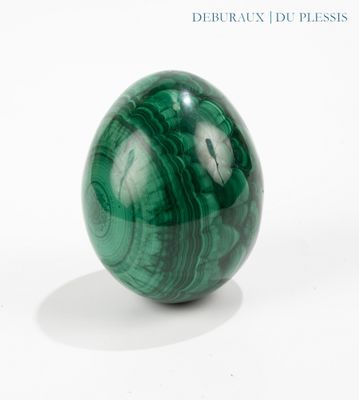 a green marble ball sitting on a white surface