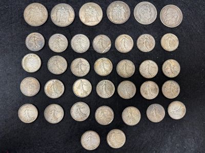 an image of a pile of old silver coins on a black surface