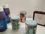 several bottles of liquid sitting on a table next to a picture frame