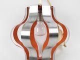 an orange and silver light fixture with a light bulb hanging from it ' s side