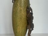 un vase vert posé sur un socle