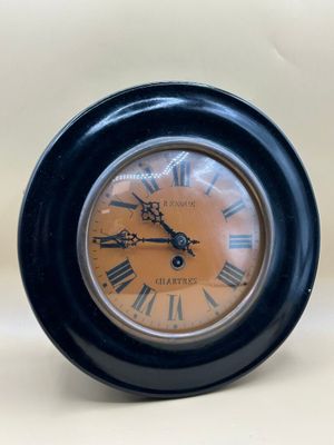 une horloge noire avec des chiffres romains
