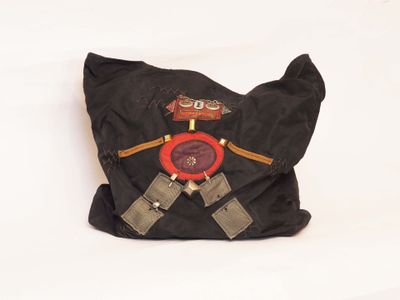 a black bag with a red button on it