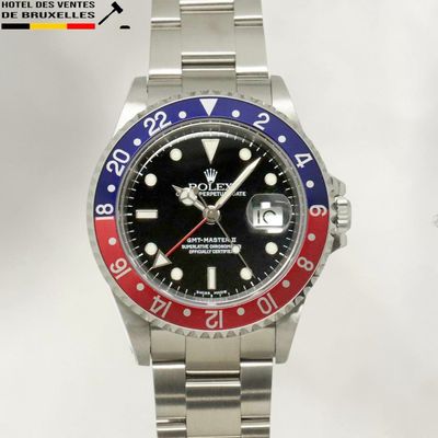 a rolex watch with a red, blue and red bezel