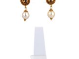 gros plan d'une paire de boucles d'oreilles sur une surface blanche