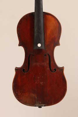 an old violin hanging from the back of a white wall